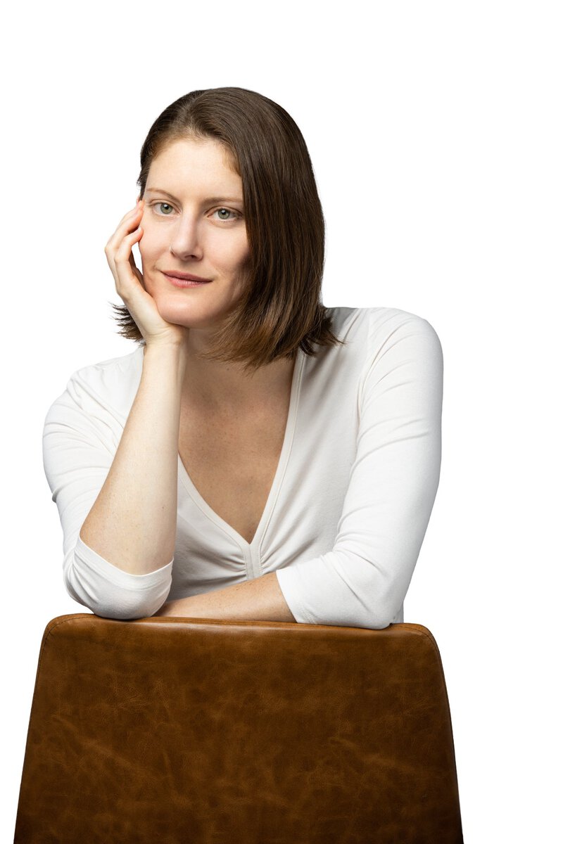 Close-up portrait of a woman with brown hair and white top, professional photography.